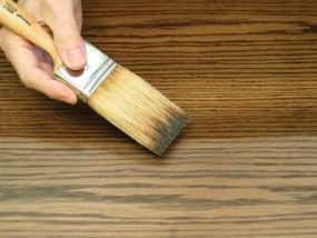 applying wood finish with a brush